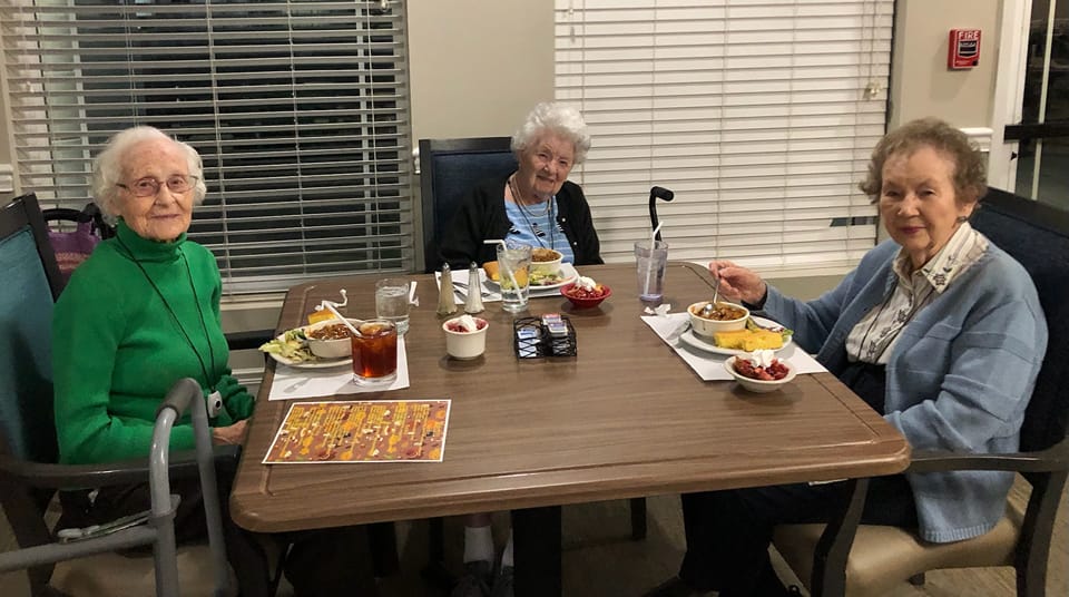 three senior women eating dinner in the dining room